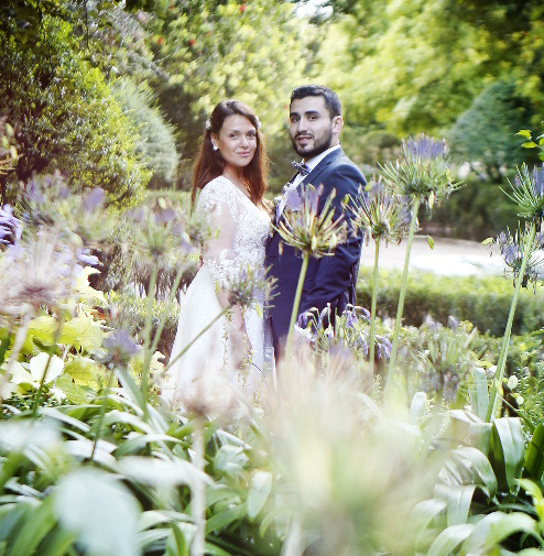 Un homme et une femme mariés derrière des fleurs dans un jardin portugais de Lisbonne